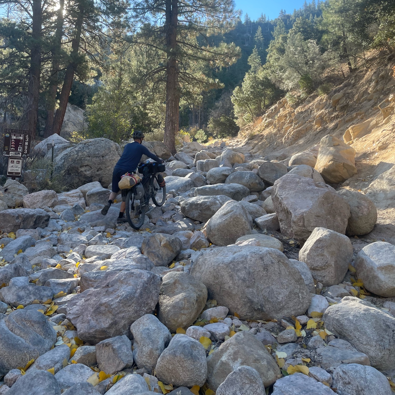 Bart pushing his bike over boulders